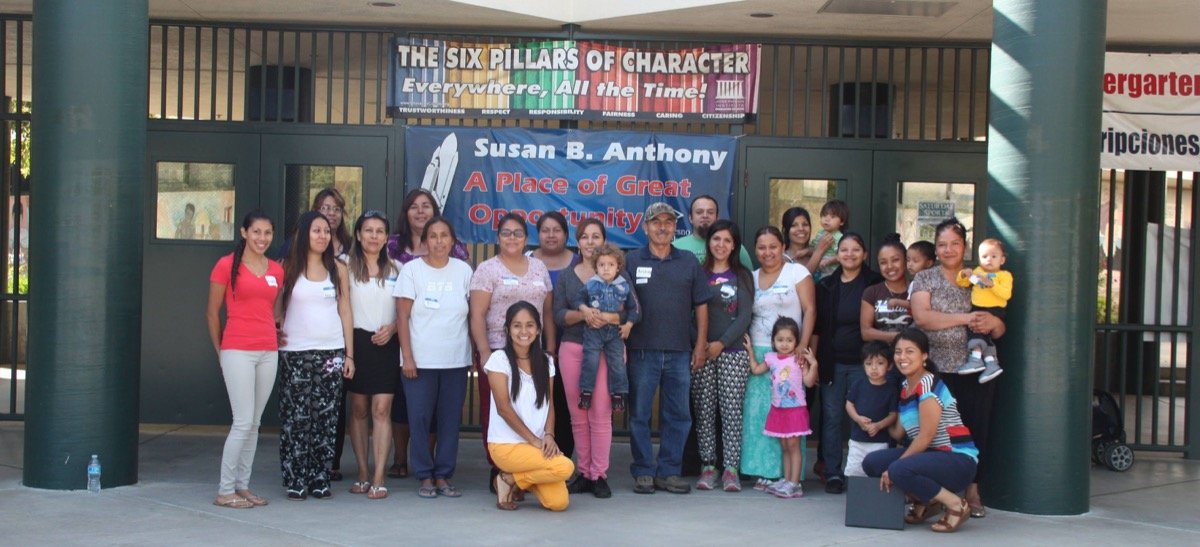 Ariana with a large group of parents and children gathered outside Susan B. Anthony school
